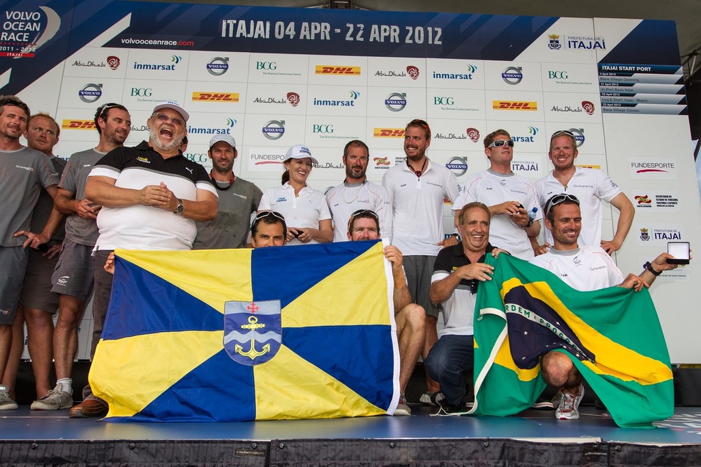 Groupama Sailing Team, skippered by Franck Cammas from France, celebrate on stage with President of the City Council, Luiz Carlos Pisseti and Mayor of Itajai, Jandir Belilini, as they finish leg 5 of the Volvo Ocean Race 2011-12 © Ian Roman/Volvo Ocean Race http://www.volvooceanrace.com